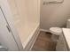 Bathroom with tub and toilet adjacent to a light vanity cabinet at 7810 Capps Ferry Rd, Douglasville, GA 30135