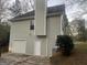 Exterior of house with white garage door, small window, and light green siding at 7810 Capps Ferry Rd, Douglasville, GA 30135
