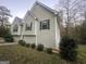 Side view of home with light green siding, green shutters, and well manicured landscape at 7810 Capps Ferry Rd, Douglasville, GA 30135