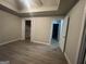 Spacious main bedroom with tray ceiling, walk-in closet, and modern vinyl flooring at 7810 Capps Ferry Rd, Douglasville, GA 30135