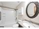 Updated bathroom featuring tub/shower, granite counter, large oval mirror, and vanity storage at 415 Southmoor Cir, Stockbridge, GA 30281