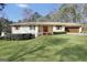 Lovely single-story home with a lush green lawn, complemented by mature trees and shrubs at 415 Southmoor Cir, Stockbridge, GA 30281