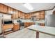 Well-lit kitchen featuring wooden cabinetry, stainless steel appliances, and a neutral-toned backsplash at 415 Southmoor Cir, Stockbridge, GA 30281