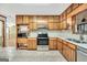 A bright kitchen with wood cabinets, stainless steel appliances, and durable countertops, great for cooking at 415 Southmoor Cir, Stockbridge, GA 30281
