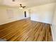 Spacious living room featuring wood-look floors, ceiling fan, and ample natural light at 36 Reese St, Grantville, GA 30220