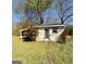 Exterior view of a shed surrounded by greenery with a window, door, and covered area at 36 Reese St, Grantville, GA 30220