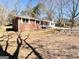 A serene backyard featuring a brick house with ample sunlight, and a well-maintained lawn at 1209 Topaz Ln, Villa Rica, GA 30180