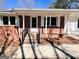 Covered front porch with classic white columns and brick accents providing a welcoming entrance to the home at 1209 Topaz Ln, Villa Rica, GA 30180