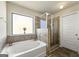 Bathroom featuring soaking tub and glass enclosed shower with tile surround at 536 Caledon Way, Hampton, GA 30228
