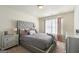 Bedroom featuring tufted headboard, carpet flooring, a dresser and large picture window at 536 Caledon Way, Hampton, GA 30228