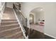 Elegant staircase featuring carpeted steps and dark wood railing leading to an upstairs landing at 536 Caledon Way, Hampton, GA 30228