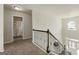 Upstairs hallway with neutral carpeting and lighting with access to the bedrooms and bathrooms at 536 Caledon Way, Hampton, GA 30228