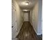 Hallway with hardwood flooring, neutral walls, white trim, and white doors at 305 Magnolia Gardens Walk, Mcdonough, GA 30253