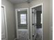 Hallway leading to bedrooms, each featuring carpeted floors and bright natural light at 305 Magnolia Gardens Walk, Mcdonough, GA 30253