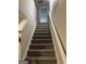 Carpeted stairway leading to the upper level, featuring a white handrail and neutral wall color at 305 Magnolia Gardens Walk, Mcdonough, GA 30253