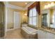 Bathroom with a soaking tub, double vanities with granite countertops, and shower with glass door at 3786 Turnberry Ct, Duluth, GA 30096