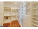 Walk-in closet with custom shelving and drawers with wood floor and bright overhead lighting at 3786 Turnberry Ct, Duluth, GA 30096