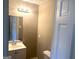 Half bathroom featuring a vanity sink, toilet, and vanity lighting at 6740 Davidson Ct, Lithonia, GA 30058