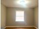 This bedroom is equipped with wood flooring, a window with blinds, and neutral paint at 6740 Davidson Ct, Lithonia, GA 30058