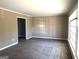 Spacious living room featuring neutral carpet, trim, and ample natural light at 6740 Davidson Ct, Lithonia, GA 30058