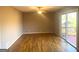 An open living area with wood floors, a ceiling fan, and a sliding door to the outdoor deck at 6740 Davidson Ct, Lithonia, GA 30058