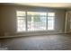 Bright living room featuring a large window and neutral-toned walls and carpet at 6740 Davidson Ct, Lithonia, GA 30058