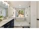 Bathroom featuring soaking tub, a view to the outdoors, and modern fixtures at 4217 Paces Ferry Se Rd, Atlanta, GA 30339