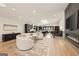 Open-concept living space with hardwood floors, a modern fireplace, and a stylish sectional sofa at 4217 Paces Ferry Se Rd, Atlanta, GA 30339