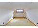 Finished attic space with neutral carpet and good lighting from center window, perfect for storage at 240 Sandy Lake Cir, Fayetteville, GA 30214