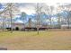 A large backyard featuring the back of the house with a stone chimney at 240 Sandy Lake Cir, Fayetteville, GA 30214