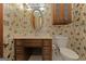Bathroom features butterfly wallpaper, a wooden vanity with storage, sink, toilet and a light fixture at 240 Sandy Lake Cir, Fayetteville, GA 30214