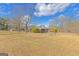 Charming exterior view of the house with a long yard and mature trees adding natural beauty at 240 Sandy Lake Cir, Fayetteville, GA 30214