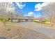 Sprawling home with a large driveway and unique covered parking area, set against a blue sky at 240 Sandy Lake Cir, Fayetteville, GA 30214