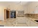 Well-lit kitchen with granite countertops, updated appliances, and classic white cabinetry at 240 Sandy Lake Cir, Fayetteville, GA 30214