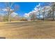 The home with a large yard with mature trees on a partly cloudy day at 240 Sandy Lake Cir, Fayetteville, GA 30214