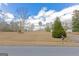 Street view with large yard surrounded by mature trees, providing privacy and a natural setting at 240 Sandy Lake Cir, Fayetteville, GA 30214