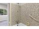 Bathroom shower with mosaic tile surround and chrome shower fixtures with grab bar and soap dish at 2544 Overlook Dr, East Point, GA 30344