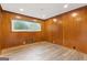 Bedroom with brown wood paneling on the walls, wood-look floors, and a window at 2544 Overlook Dr, East Point, GA 30344
