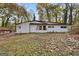 Charming white brick home featuring black trim and mature trees at 2544 Overlook Dr, East Point, GA 30344