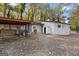 Charming white brick home with a carport and storage shed surrounded by colorful fall foliage at 2544 Overlook Dr, East Point, GA 30344