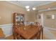 Elegant dining room features wood table set, wood china cabinet, and white wainscoting at 509 Carleton Pl, Locust Grove, GA 30248