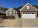 Welcoming brick home with a two-car garage, manicured landscaping, and a charming front entrance at 509 Carleton Pl, Locust Grove, GA 30248