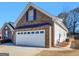 Front elevation featuring a two-car garage and brick facade at 509 Carleton Pl, Locust Grove, GA 30248