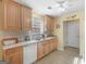 Kitchen featuring light wood cabinets, white appliances, and a view of the dining area at 509 Carleton Pl, Locust Grove, GA 30248