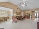 Open-concept living room showcasing vaulted ceiling, tan paint, and seamless flow to kitchen and dining areas at 509 Carleton Pl, Locust Grove, GA 30248