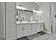 A bathroom with double sinks, white cabinets, grey walls, and modern light fixtures at 285 Hogan Coweta Rd, Hogansville, GA 30230