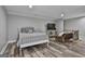 Cozy bedroom features hardwood floors, TV, and a comfortable sitting area by the stairs at 285 Hogan Coweta Rd, Hogansville, GA 30230