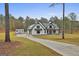 Wide shot of a stylish farmhouse with long driveway, garage, storage shed, and wooded backdrop at 285 Hogan Coweta Rd, Hogansville, GA 30230