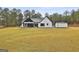 Exterior view of modern farmhouse with large backyard, covered patio and additional storage structure at 285 Hogan Coweta Rd, Hogansville, GA 30230