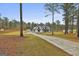 A sprawling farmhouse estate featuring a long driveway, accessory building, and mature trees at 285 Hogan Coweta Rd, Hogansville, GA 30230
